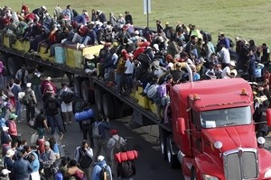 图为中美洲“大篷车移民”经过墨西哥涌入美墨边境。（图：AP）