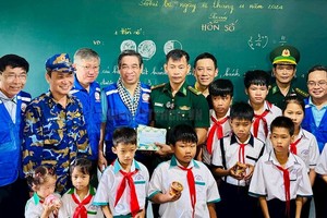 市委副书记阮福禄(后排左四)向岛上学生赠送礼物。（图：市党部新闻网）