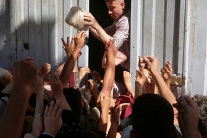 在加沙地带中部的代尔巴拉赫向加沙人分发面包。（图：联合国近东救济工程处 ）