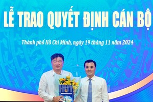 市人委会副主席裴春强（右）向潘文邓同志颁授《决定》并赠送鲜花祝贺。（图：市党部新闻网）