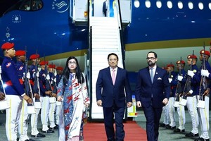 政府总理范明政偕夫人和越南高级代表抵达首都圣多明各美洲国际机场，开始进行正式访问。（图：越通社）