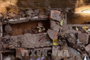 距路面1米多的深度，施工队发现了许多装有遗骸的小石棺。（图：越通社）