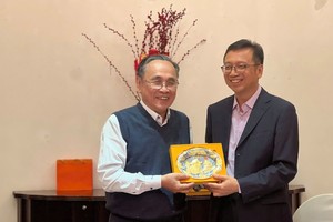 陈抗战常务副主席（左）向周彤副主任赠送纪念品