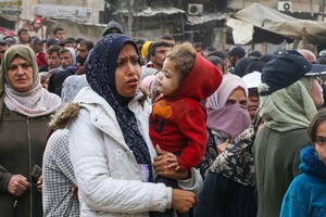 妇女和儿童在汗尤尼斯的一家面包店排队购买面包。（图：联合国）