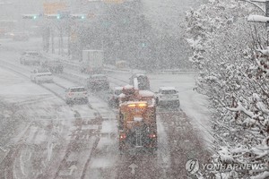 除雪车展开除雪工作。（图：韩联社）
