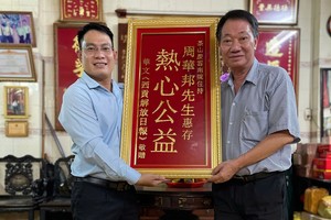 本报编委文忠孝（左）向茶山庆云南院住持周华邦赠送礼物。