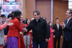 政府总理范明政同与会代表握手致意。