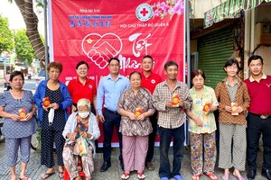 本报编委文忠孝与第六郡红十字会正、副主席派发礼物。