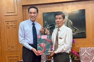 驻胡志明市台北经济文化办事处副处长曾晓峯（左）向《西贡解放报》赠送新年礼物。