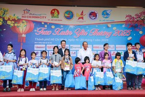  政府原常务副总理张和平和越南青商会主席邓鸿英颁赠礼物给贫困少儿。