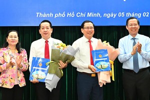 市人委会主席潘文迈、市人民议会主席阮氏丽向两位同志颁授《决定》。