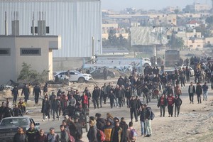 流离失所的巴勒斯坦人在加沙地带的一条街道上行走。