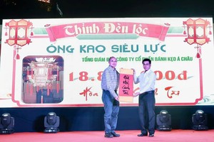 市人委会副主席阮文勇祝贺亚洲饼家(ABC Bakery)总经理高肇力投得圣灯。