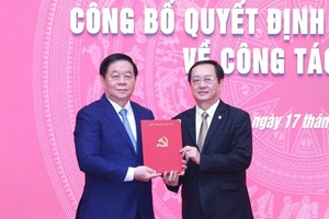 中央宣教与民运部长阮仲义（左）向黄成达同志颁授《决定》