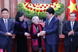 国家主席梁强问候阮氏金莱护士，昔日在潘悛新闻工作者的黑白图片作品中的“小游击员”。