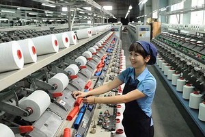 纱线厂工人正全神贯注工作。