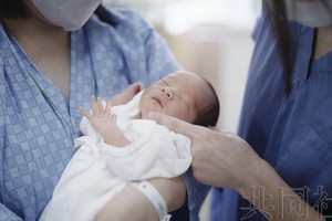 母亲怀抱新生儿。（图：共同社）