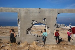 孩子们聚集在一栋被摧毁的建筑前。（图：联合国）