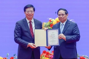 清华大学党委书记邱勇教授向越南政府总理范明政授予清华大学“名誉教授”称号。（图：越通社）