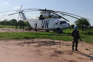 一名南苏丹特派团维和人员守卫着一架紧急降落的直升机。（图：南苏丹特派团）