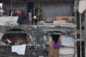 2025年3月9日，在穆斯林斋月开斋前，两名流离失所的巴勒斯坦女孩在加沙北部城镇拜特拉希亚（Beit Lahia）一个破房子里暂时栖身。（图：AFP）