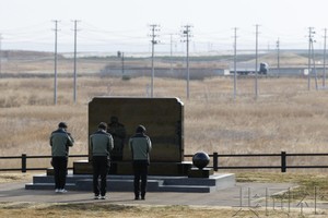 人们在建于高地的慰灵碑前悼念遇难者。（图：共同社）