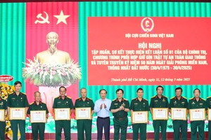 中央宣教与民运部副部长范必胜、越南退伍军人协会副主席屈越勇中将向模范退伍军人颁授奖状。（图：锦雪）