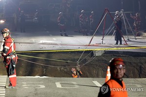 3月24日下午，在首尔江东区路面塌陷事故现场，消防队员开展搜救工作。（图：韩联社）