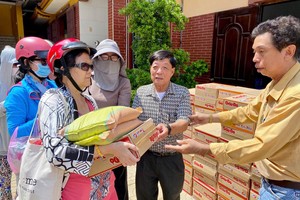 热心人士倪耀茂（右二）向视障人士发送方便面和大米。