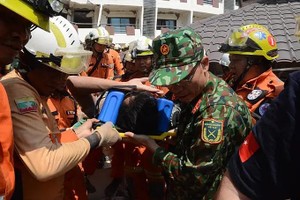 越南同缅甸与土耳其的救援力量将受害者抬出急救车。（图：越通社）