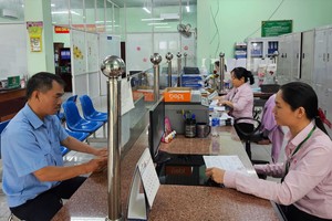 第十二郡优抚政策银行交易科干部与职工为民众解决贷款卷宗。