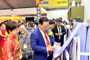 越南纺织协会主席武德江与各代表参观展品。