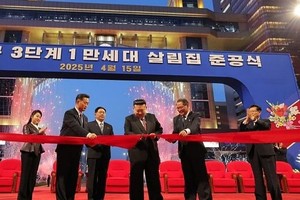 金正恩为项目竣工剪䌽，金主爱(左一)在旁拍手。（图：朝中社）