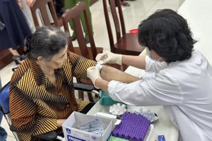 医护人员正在为尚未确实身份烈士亲属采集DNA样本。（图：锦雪）