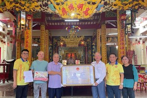 市龙狮协会主席卢耀南、副主席阮玉秀向海南会馆理事会代表赠送市华人龙狮艺术获列入国家级非物质文化遗产名录认证。