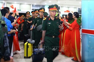 百民众热烈欢迎鼓掌、欢呼，手持金星红旗迎风飘扬迎接近200名身穿整齐军服、背着行囊前来南方参加节日纪念任务的军队战士。（图：越通社）