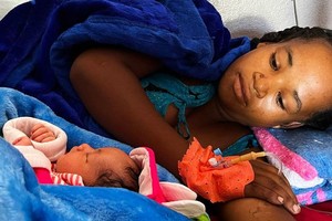 马达加斯加南部一家医院里，一位年轻的母亲抱着新生儿休息。（图：联合国）