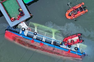 救援人员在对倾覆船只进行搜救(无人机照片)。（图：新华社）