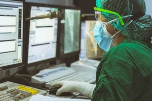 在印度尼的西亚科塔马卡萨，一名护士在导管控制室工作。（图：联合国）