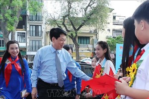 国家主席梁强微笑着向夹道欢迎的少先队员们致意。（图：越通社）