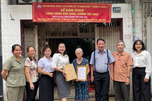 地方领导与庆云南院住持周华邦向黎氏红蝶一户移交“温情屋”工程。