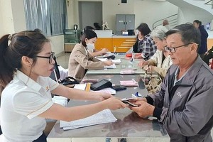 一名退休大叔在当地所住的坊级人委会办事处领取月退休金。（示意图：禅镫）