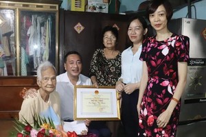 市人民议会副主席范成坚（左二）与代表团向古芝县高龄人模范阮氏款（左一）祝寿并赠送贺寿状。