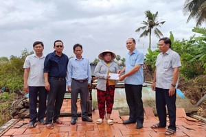 金瓯省乌明县人委会领导向受灾害影响的民户提供资金支援。（图：金瓯报）