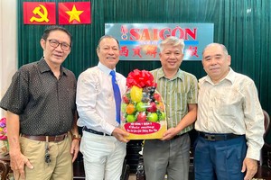 第五郡东医会向本报编委黎曰孟雄(左三)赠送礼物祝贺。