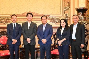 市人委会主席阮文得（中）同日本贸易振兴机构胡志明市代表团合影。（图：越勇）
