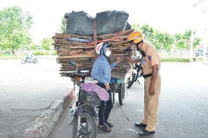 执勤交警截停一辆改装摩托车运载着超大货物。（图：越通社）