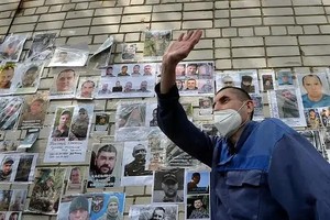 6月12日，一名被释放的乌军人员向等候的家属挥手。（图：新华社）