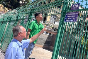 穗城会馆理事长卢耀南指导装新门牌。