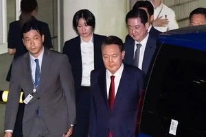 7月9日晚，韩国前总统尹锡悦接受讯问后走出首尔中央地方法院。（图：新华社）